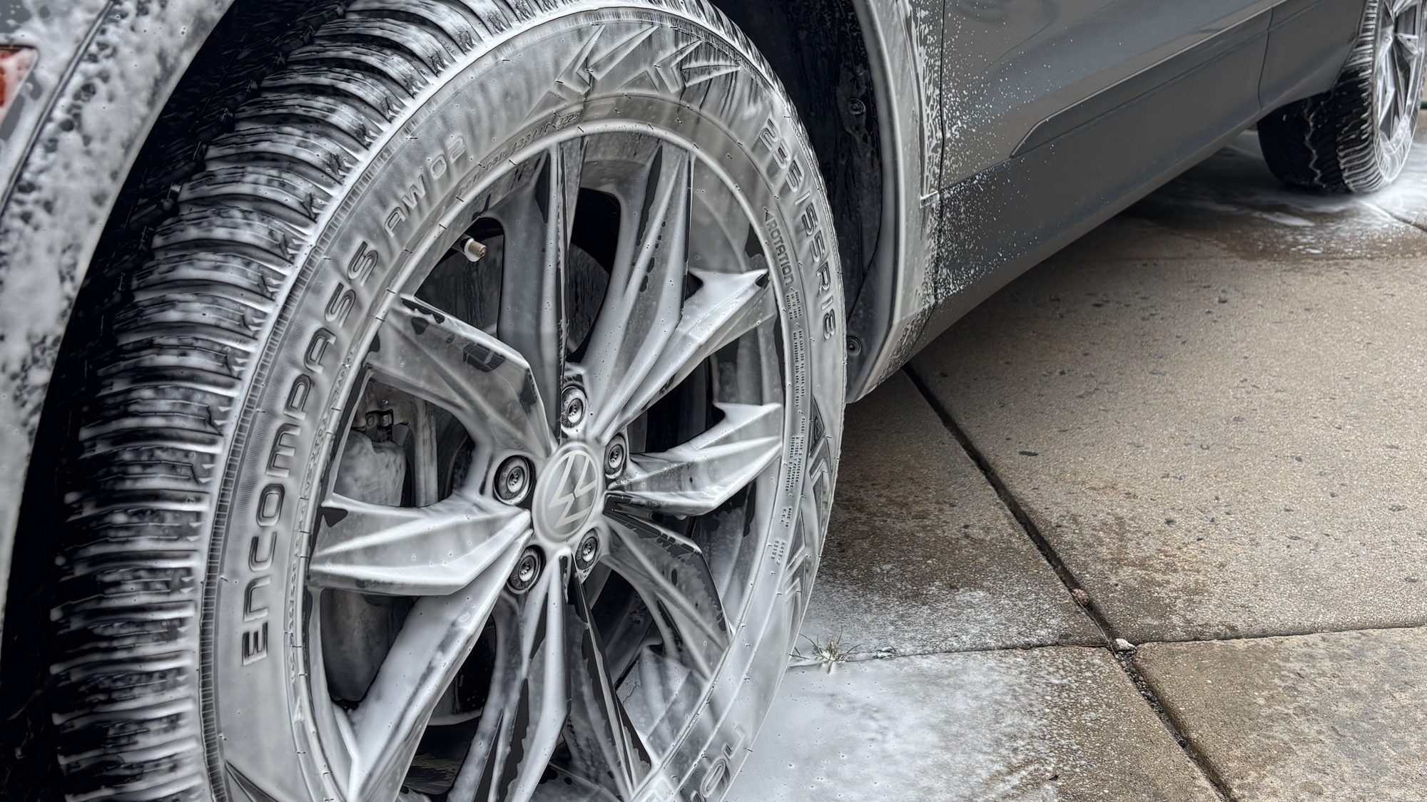 A wheel covered in cleaning foam during a hand wash