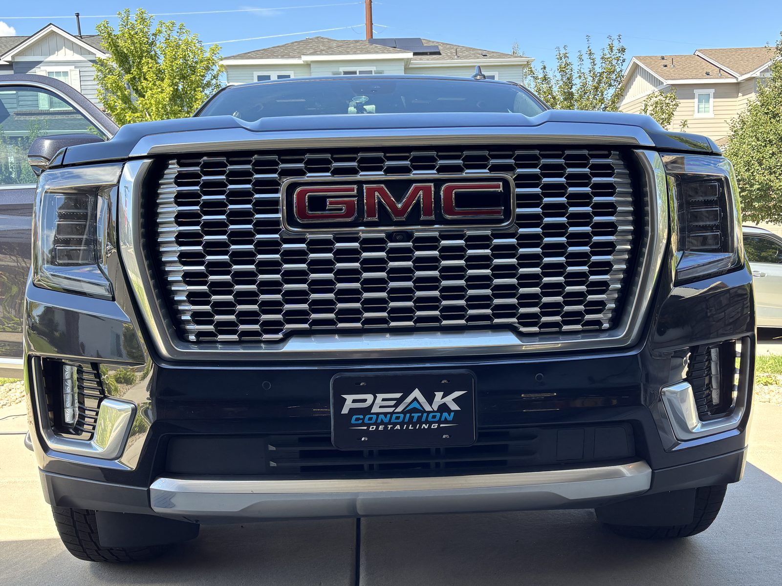 Close-up of a polished GMC grille and headlight